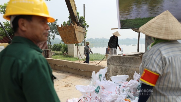 Các lực lượng tập kết phương tiện, vật tư tại khu vực cửa khẩu đê Đô Tân, chuẩn bị thực hành xử lý tình huống nước lũ dâng cao. Ảnh: Trung Nguyên