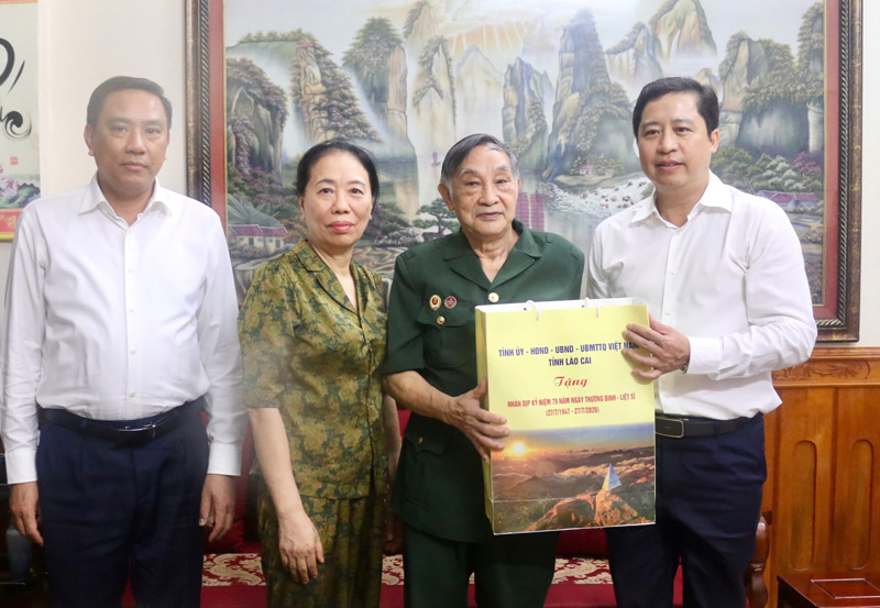 Lao Cai Provincial Party Secretary Duong Quoc Huy (far right) visits and presents gifts to wounded soldier Tran Hung Thanh. Photo: Lao Cai Information Portal