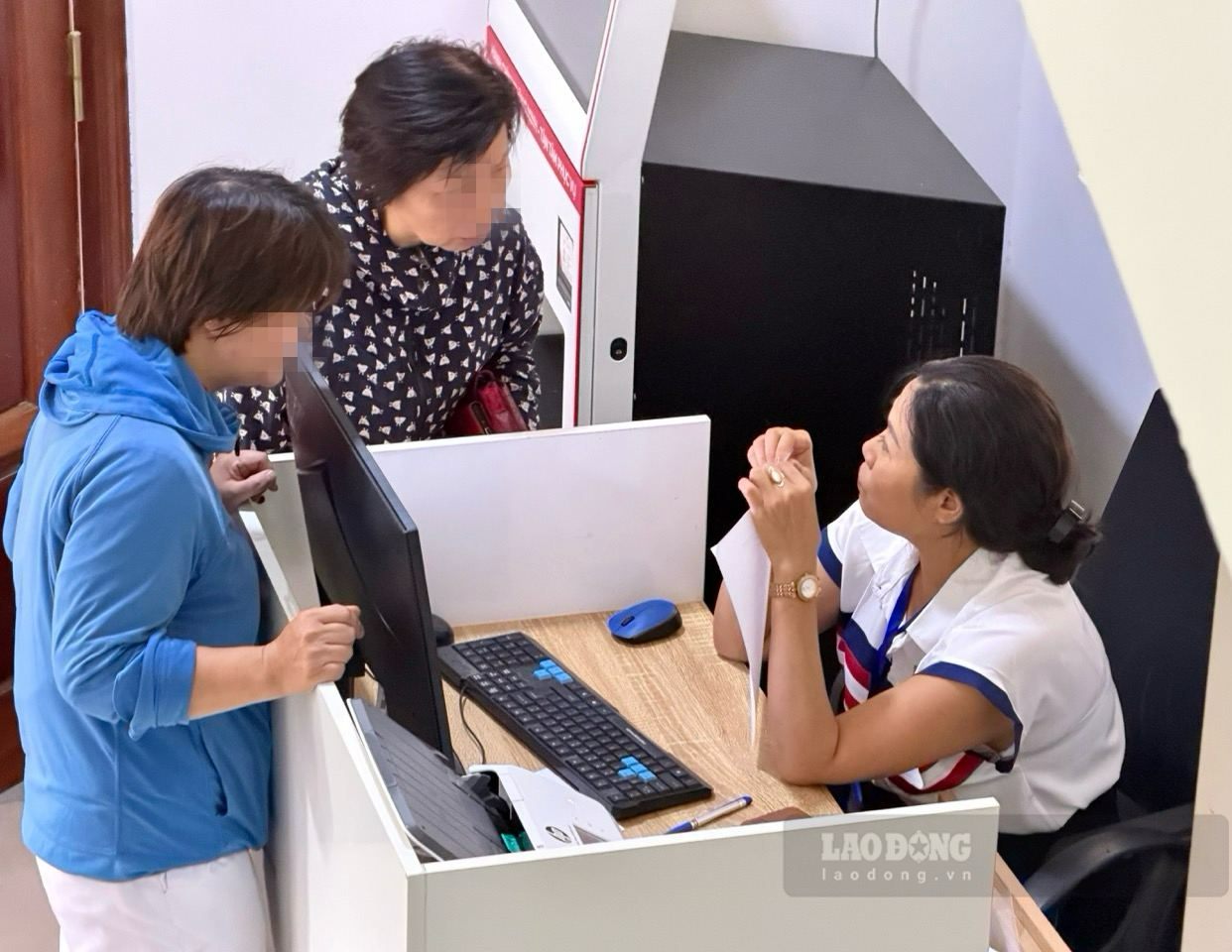 Funcionarios del Centro de Servicios Administrativos Públicos de Hanoi, sucursal número 4, guían a las personas sobre los procedimientos para autorizar la recepción de pensiones y subsidios. Foto: Thuy Linh