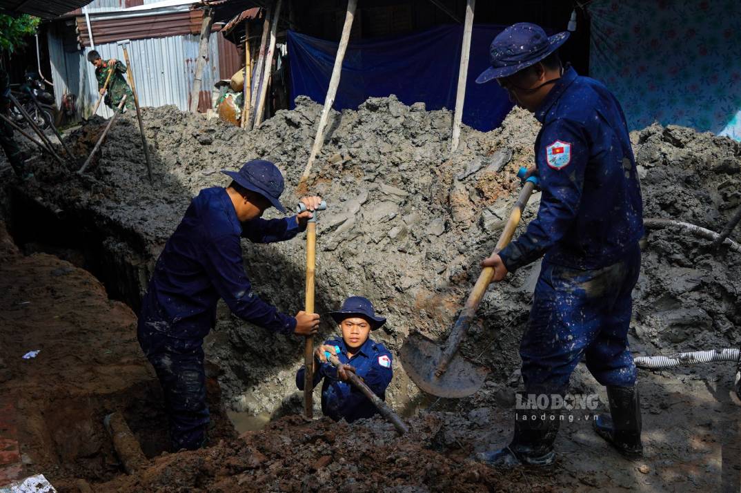 Oficiales y soldados se turnan para excavar el lugar sospechoso de tener 2 tumbas colectivas de mártires. Foto: Ta Quang