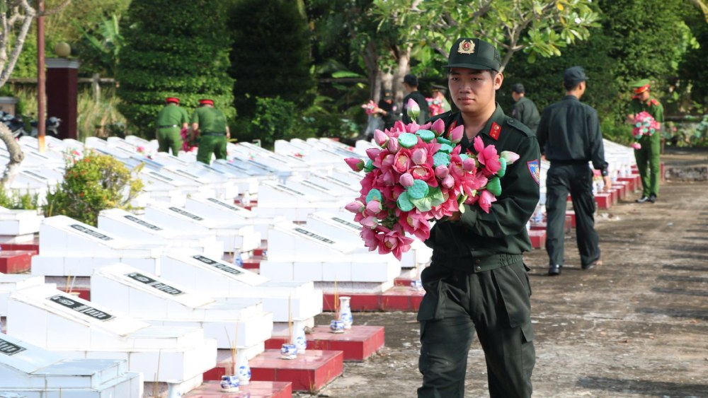 Police and union members and youth of units coordinate to clean the cemetery grounds, clean grave areas, replace flowers and vases on each martyr's grave. Photo: Tien Dung/ An Giang Police