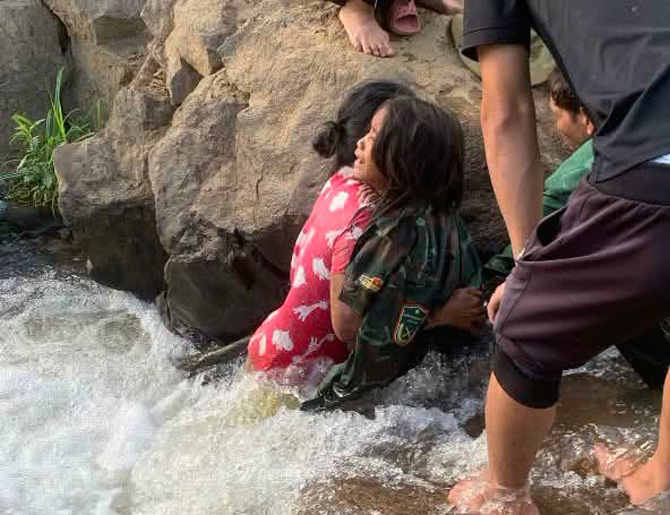 Baby Y Cuc was trapped in a cliff in the middle of a stream before being rescued. Photo: Police provided