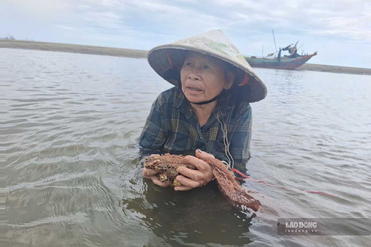 Ms. Ung is one of the women who bathes themselves every day to catch clams at Lach Ken estuary. Photo: Tran Tuan