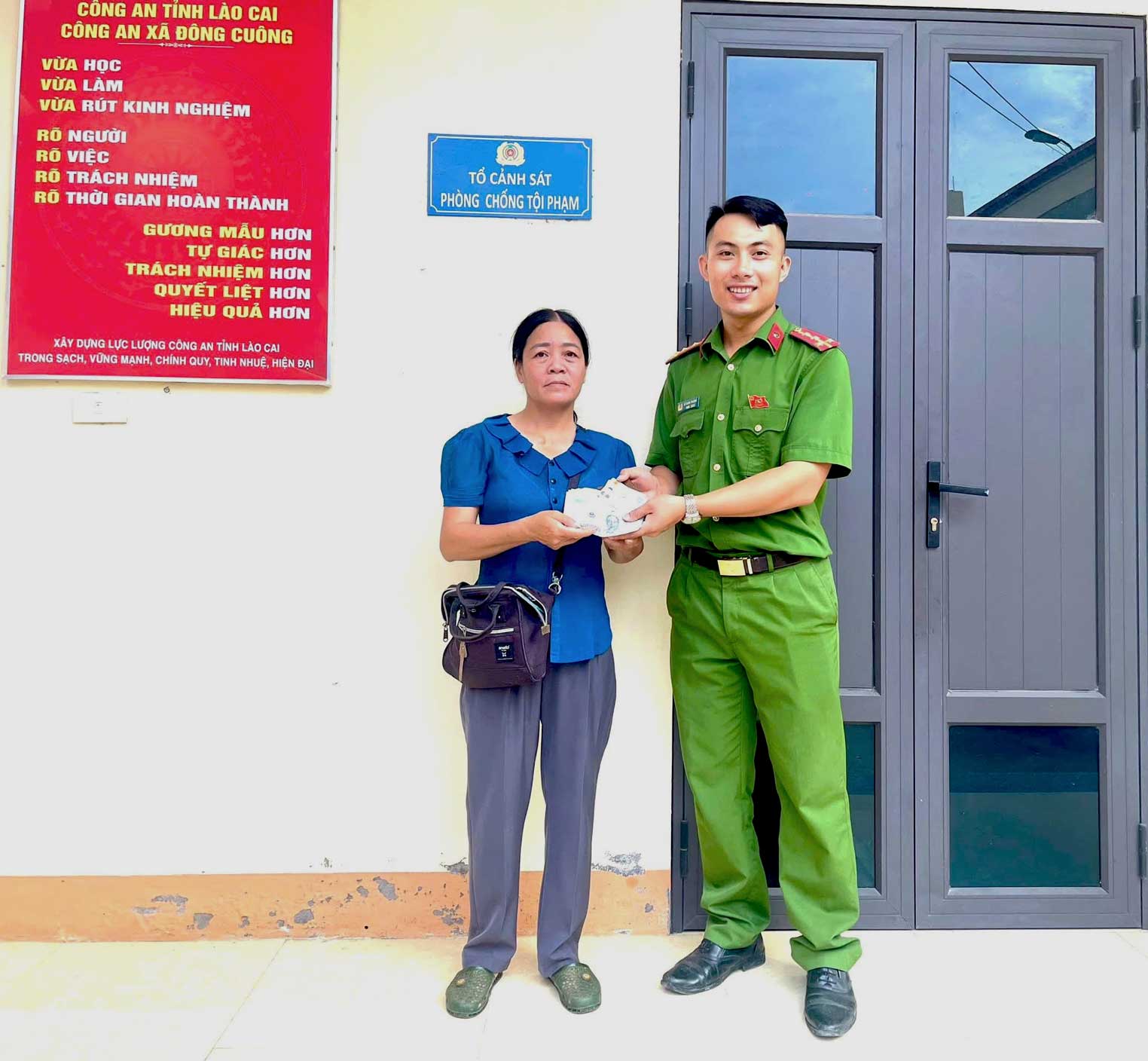 Chị Phạm Thị Lệ Hằng bàn giao chiếc ví nhặt được cho Công an xã Đông Cuông để tìm người đánh rơi. Ảnh: Công an Lào Cai
