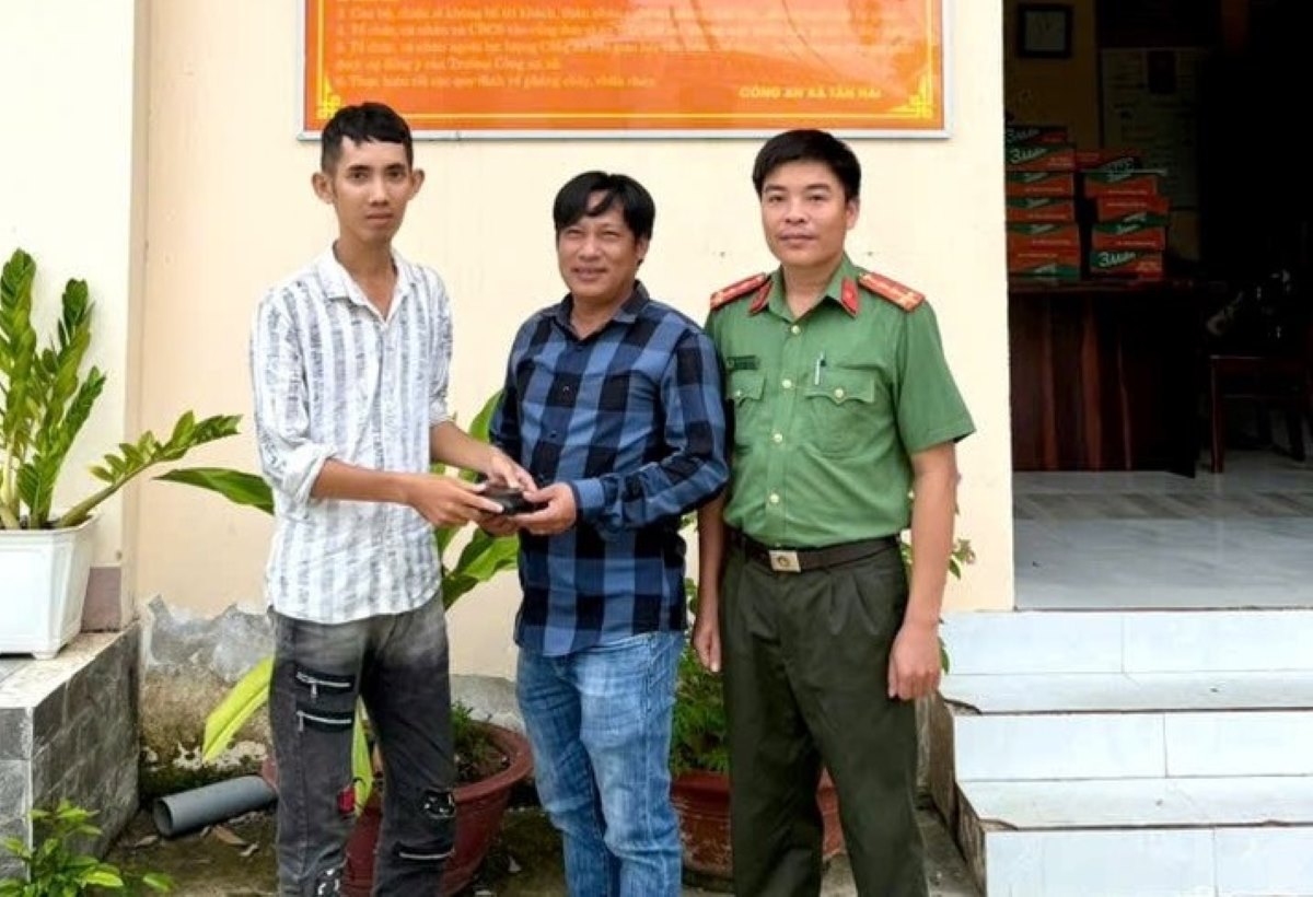 A young man returns a wallet to the person who dropped it in front of the commune police. Photo: Police provided