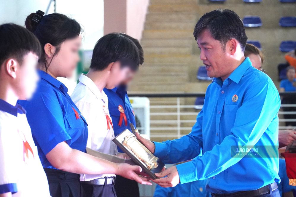 Phó Chủ tịch Ủy ban MTTQ Việt Nam TP, Chủ tịch LĐLĐ TP Đồng Nai Nguyễn Quốc Dũng trao biểu trưng cho các em học sinh được tuyên dương “Học giỏi - Sống tốt“. Ảnh: HAC