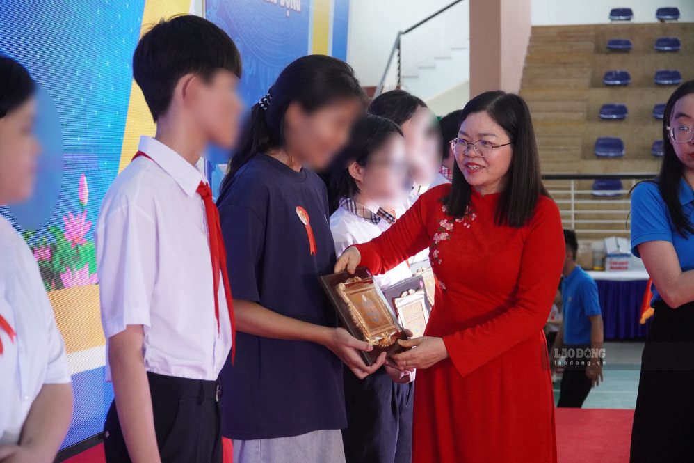 Phó Chủ tịch LĐLĐ TP Đồng Nai Nguyễn Thị Tuyết trao biểu trưng cho các em học sinh được tuyên dương “Học giỏi - Sống tốt“. Ảnh: HAC