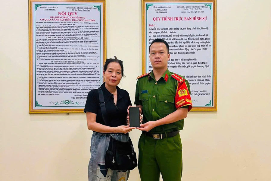 Bà Nguyễn Thị Hoa nhặt được điện thoại iPhone, bàn giao tài sản thất lạc tại trụ sở Công an xã Lục Yên. Ảnh: Cổng TTĐT Công an tỉnh Lào Cai