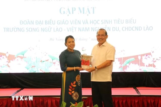 Vice Chairman of the Central Committee of the Vietnam Fatherland Front Hoang Cong Thuy receives souvenirs from Nguyen Du Lao-Vietnamese Bilingual School. Photo: VNA
