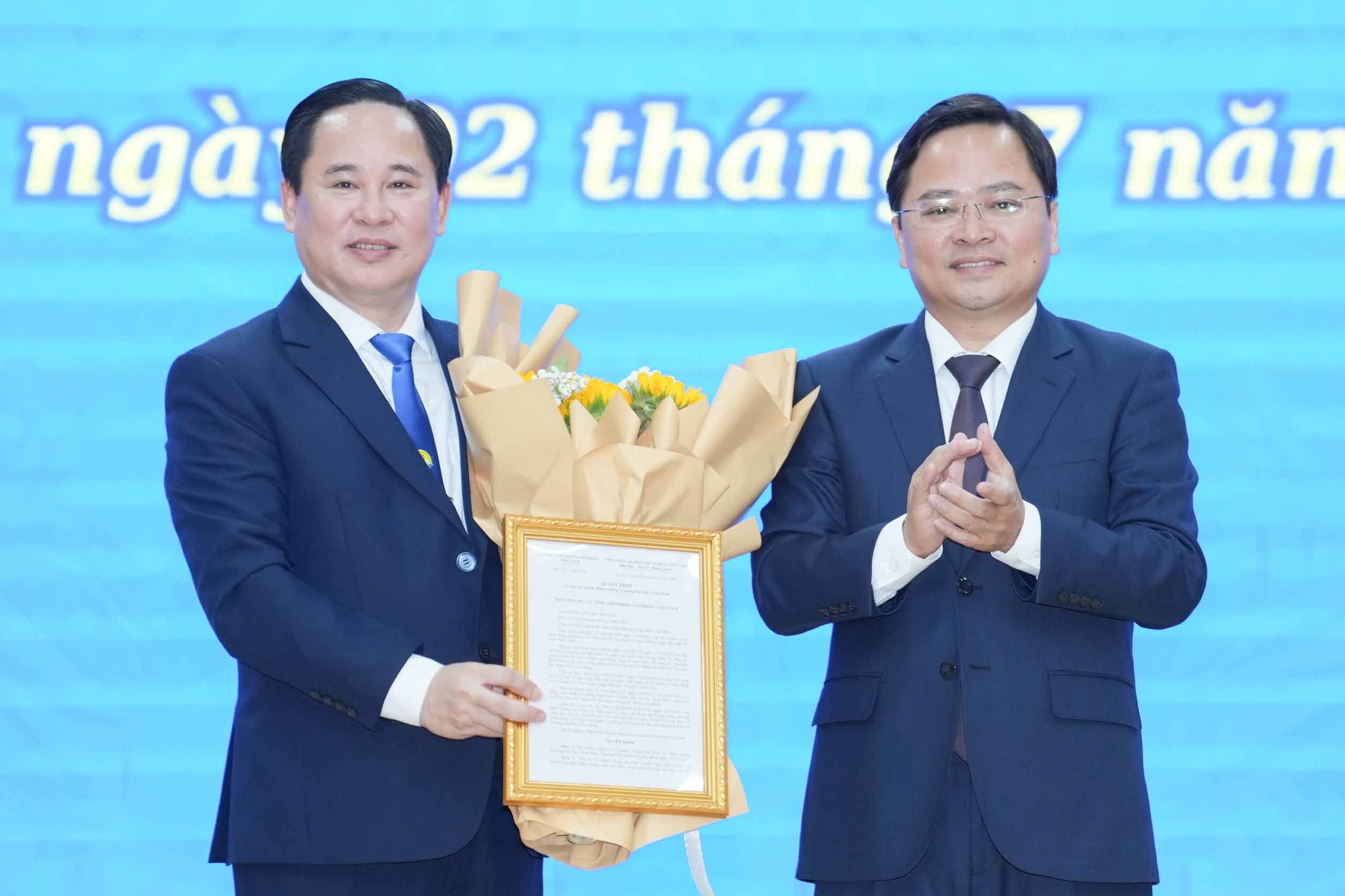 Ông Nguyễn Anh Tuấn - Ủy viên Trung ương Đảng, Bí thư Đảng ủy, Chủ tịch Tổng LĐLĐVN trao quyết định và tặng hoa chúc mừng đã chúc mừng PGS.TS. Lê Mạnh Hùng được tín nhiệm, bổ nhiệm giữ chức vụ Hiệu trưởng Trường Đại học Công đoàn. Ảnh: Hữu Chánh