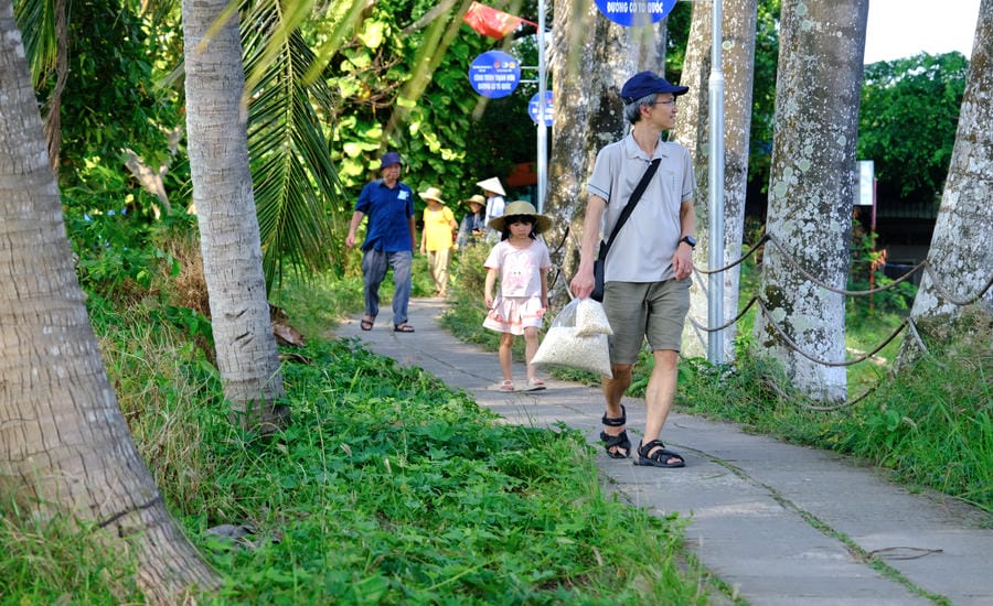 Du khách đi dạo trên con đường quê ở Cồn Sơn. Ảnh: Phong Linh