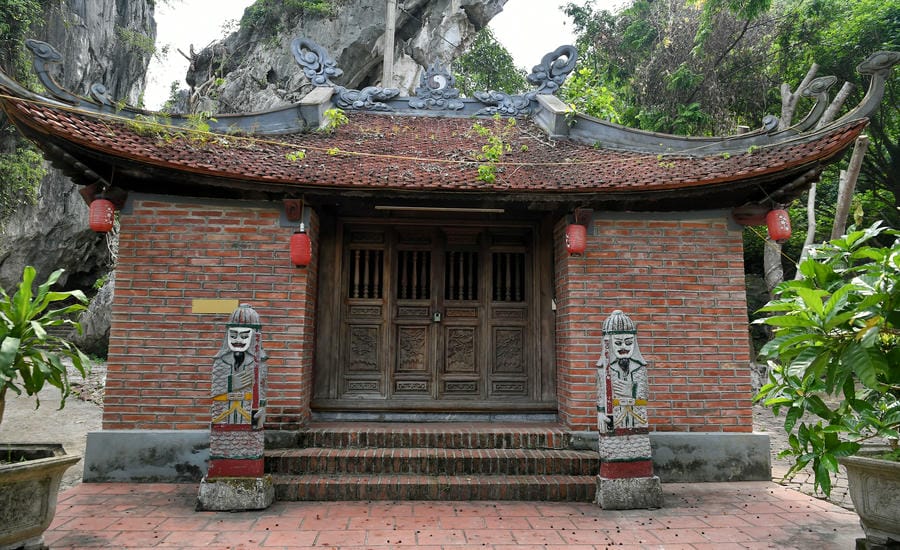 Ngôi miếu nhỏ nép mình dưới vách núi đá là một phần của quần thể chùa Hang, nơi kiến trúc truyền thống hòa quyện với cảnh quan tự nhiên.