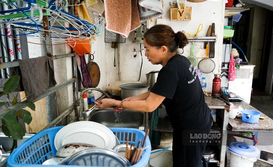 Mr. Nguyen Ngoc's wife washing dishes and clothes in the family kitchen right in front of the house. Photo: Tung Giang