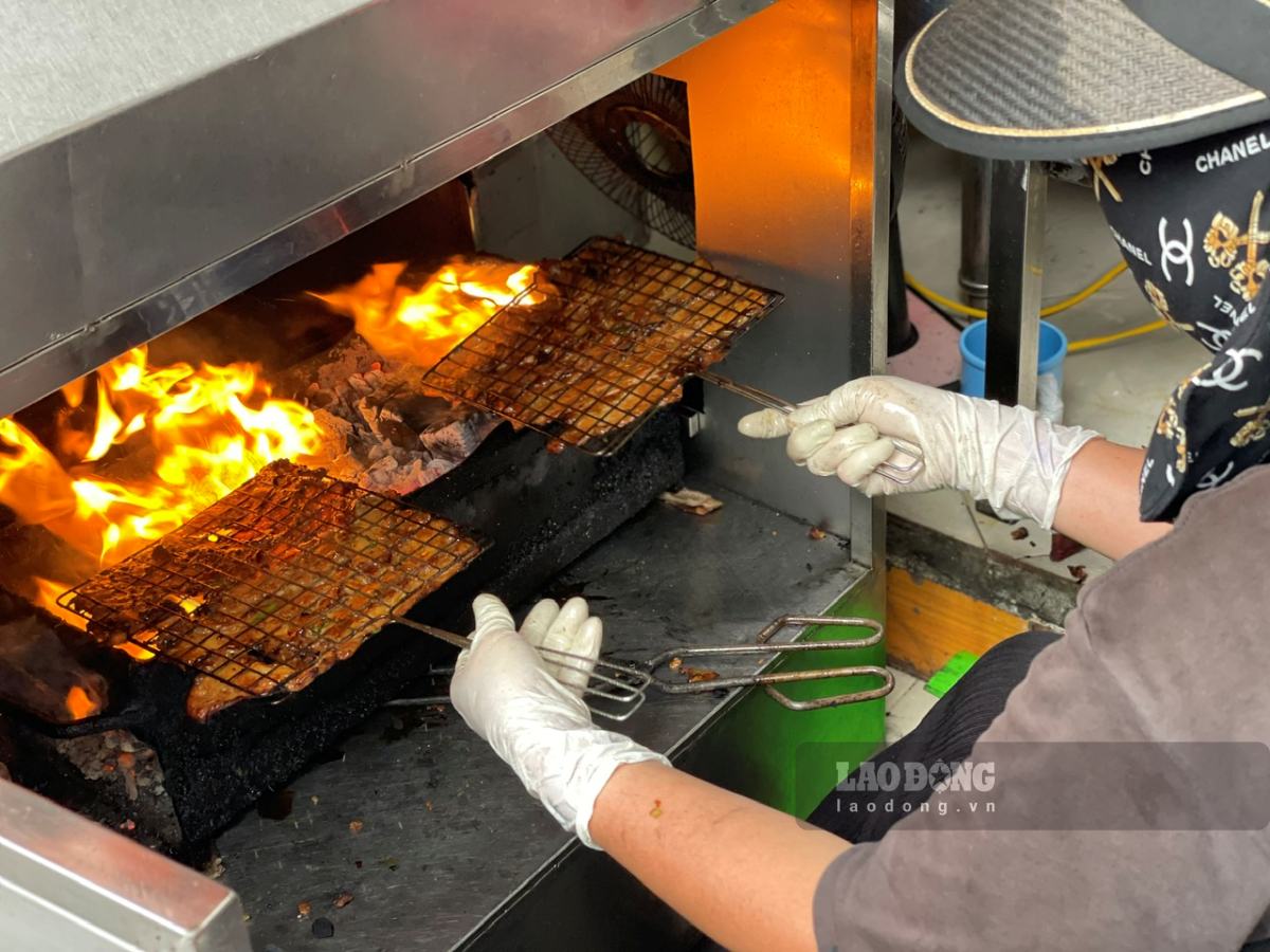 Dù nhiệt độ ngoài trời tăng cao, chị Hồng vẫn tự tay nướng từng phên thịt. Ảnh: I La