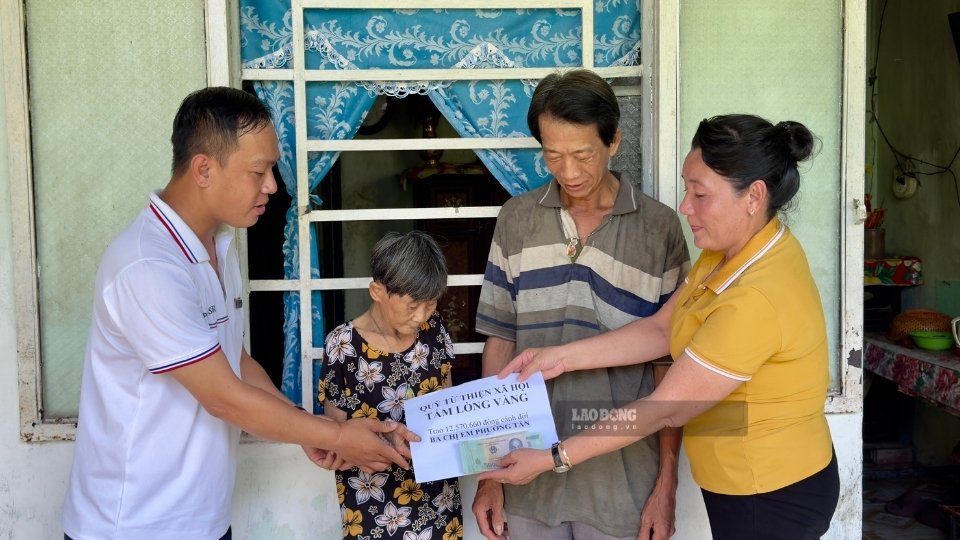 Representatives of the Golden Heart Charity Fund presented 12,570,660 VND donated by Lao Dong Newspaper readers to the family of Mr. Nguyen Buu Nhan and his three sisters. Photo: Hoang Loc
