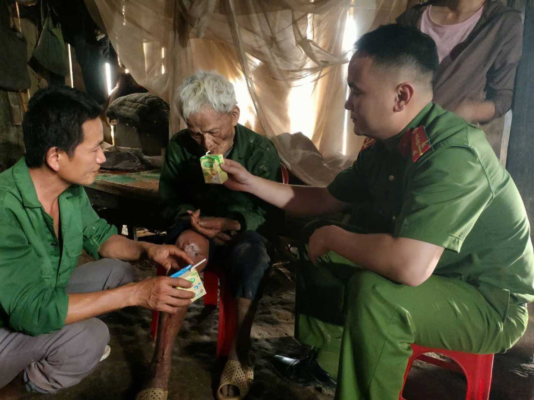 Lực lượng Công an xã Tam Kim chăm sóc, hỗ trợ cụ ông sau khi được tìm thấy trong rừng. Ảnh: Công an Tuyên Quang