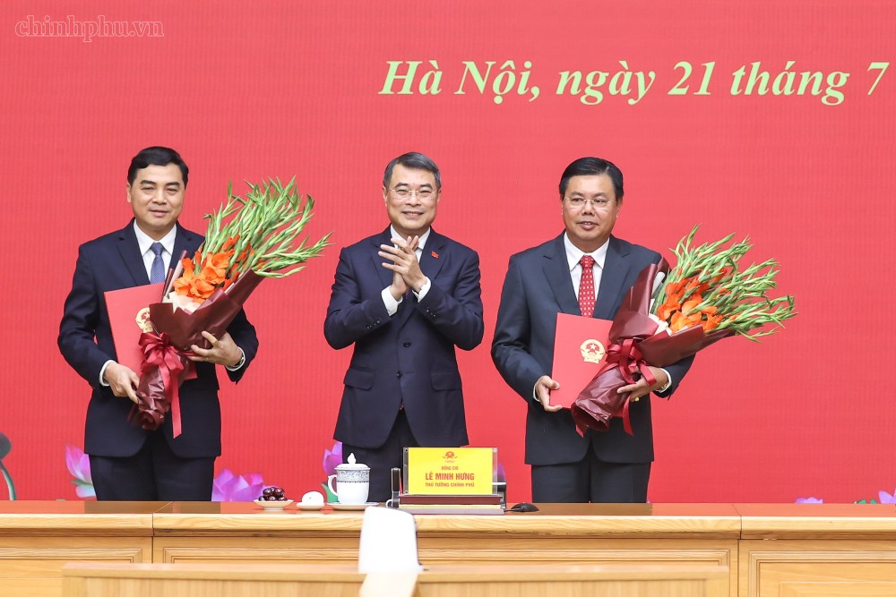 Politburo Member, Prime Minister Le Minh Hung presents flowers to congratulate Acting Minister of Home Affairs Nguyen Tien Hai (far right) and Standing Deputy Minister of Ethnic Minorities and Religious Affairs Nguyen Hoai Anh. Photo: VGP/Nhat Bac
