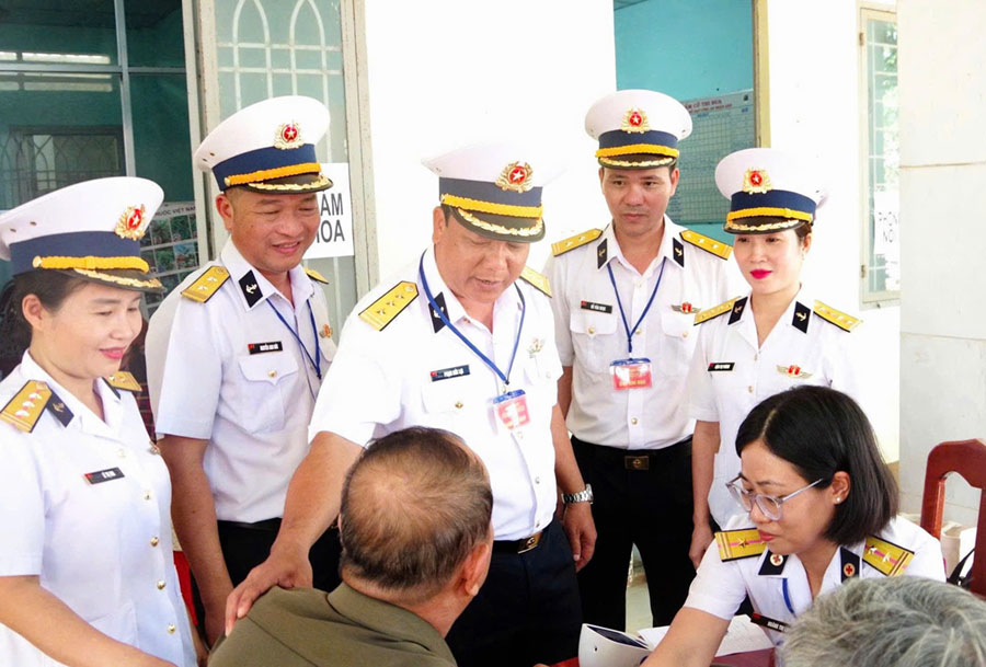 Senior Lieutenant Colonel Pham Duc Loi visits people who have been examined, consulted on health and given free medicine. Photo: Navy Command
