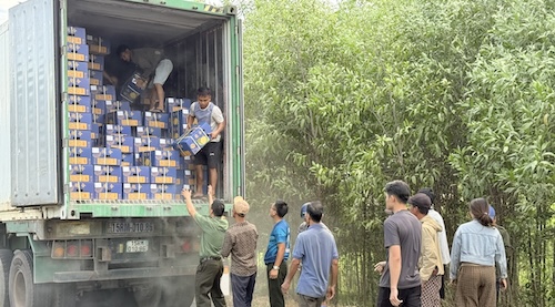 Lực lượng Công an và người dân hỗ trợ di dời tài sản ra khỏi chiếc xe container đang bốc cháy ở phần đầu xe. Ảnh: Công an Quảng Trị