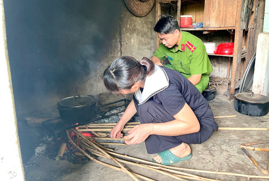 Cán bộ công an chuẩn bị bữa cơm tại gia đình cựu chiến binh Trương Văn Thịnh. Ảnh: CA Lào Cai