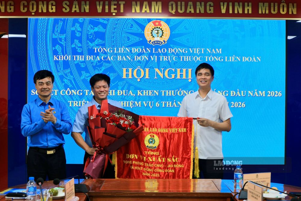 Phó Chủ tịch Thường trực Tổng LĐLĐ Việt Nam Ngọ Duy Hiểu và Phó Chủ tịch Tổng LĐLĐ Việt Nam Lê Văn Nghĩa trao Cờ thi đua của Tổng LĐLĐ Việt Nam cho Trường Đại học Công đoàn. Ảnh: Quỳnh Chi