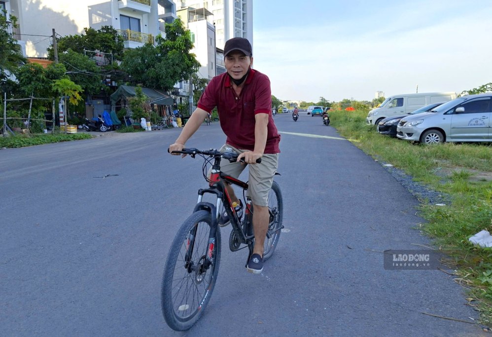 Ông Trần Văn Sơn đạp xe trên tuyến đường ven kênh.  Ảnh: Minh Quân