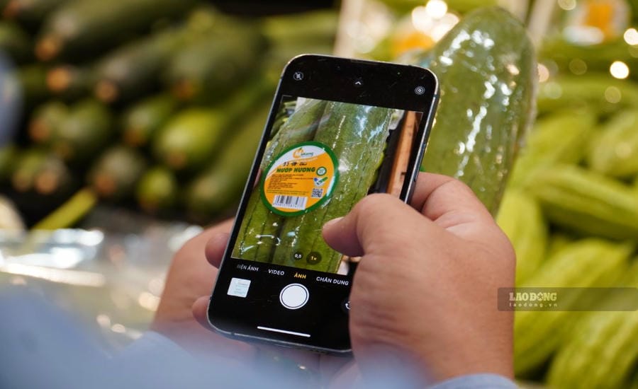 Les consommateurs scannent les codes QR pour retracer l'origine des aliments participant au programme "Tick vert de responsabilité" aux points de vente à Hô Chi Minh-Ville. Photo: Ngọc Lê