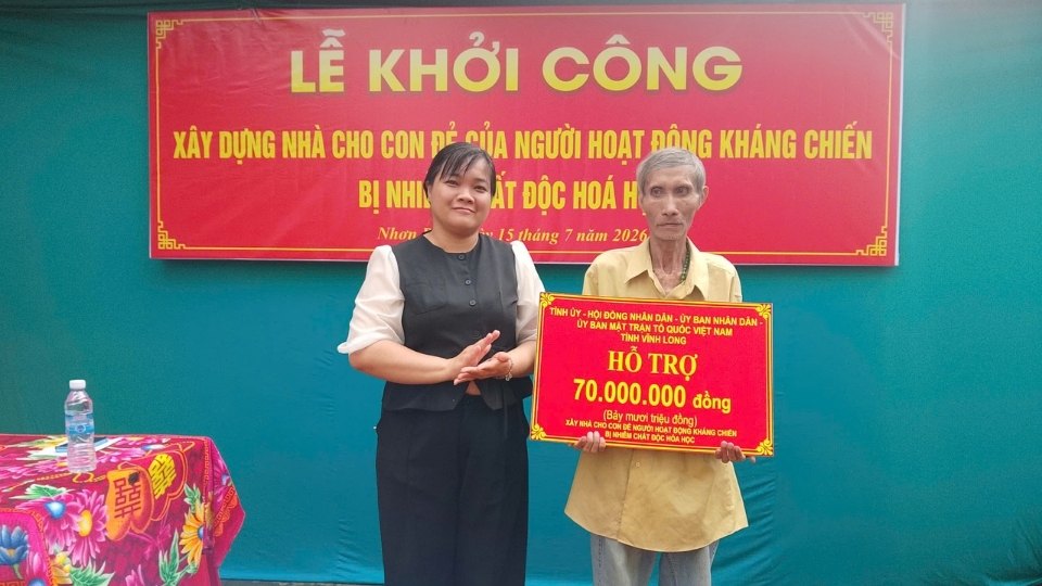 Ông Nguyễn Văn Sánh nhận bảng tượng trưng hỗ trợ 70 triệu đồng xây dựng nhà ở. Ảnh: Trung tâm DVSNC xã Nhơn Phú