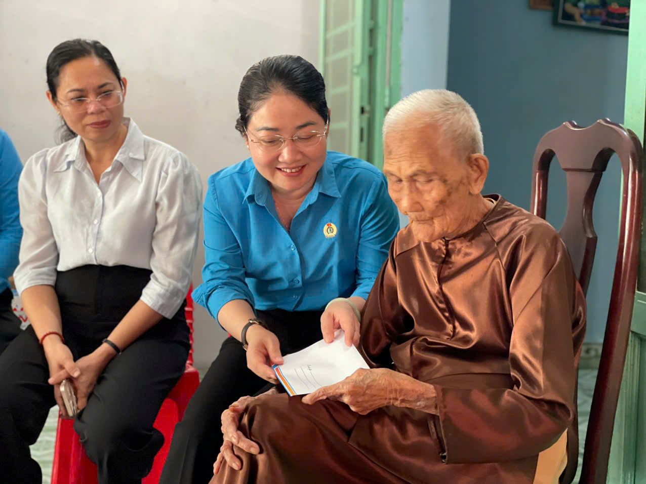 Bà Nguyễn Kim Loan - Phó Chủ tịch LĐLĐ TPHCM tặng quà Mẹ Việt Nam Anh hùng Nguyễn Thị Rực. Ảnh: Công đoàn TPHCM cung cấp
