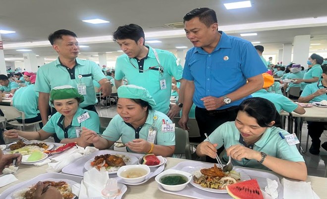 Hàng đứng từ phải sang: Ông Nguyễn Đình Thắng - Ủy viên Ban thường vụ Tổng LĐLĐVN, Chủ tịch Công đoàn các Khu công nghệ cao và khu công nghiệp Thành phố Hà Nội; ông Futaki Teruhiro - Giám đốc bộ phận hành chính nhân sự Công ty TNHH Canon Việt Nam; ông Nguyễn Anh Ngọc - Chủ tịch Công đoàn Công ty TNHH Canon Việt Nam - hỏi thăm người lao động tại Bữa cơm Công đoàn năm 2026. Ảnh: Kiều Vũ