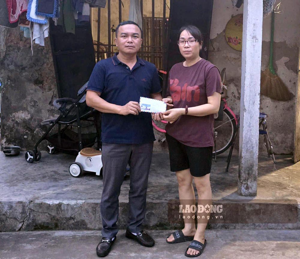 Representatives of the Golden Heart Charity Fund present money donated by readers to Vu Thi Thom, residing in Hoang Long residential group, Tay Hoa Lu ward, Ninh Binh province. Photo: Dieu Anh
