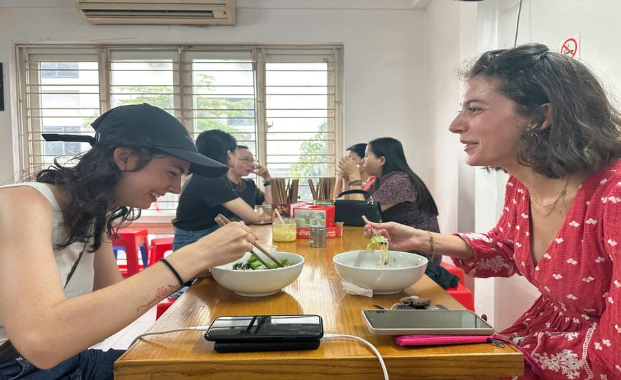 Chị Charlotte (đến từ Pháp) hào hứng chia sẻ trải nghiệm bún bò Nam Bộ với người bạn thân. Ảnh: Đình Sáng