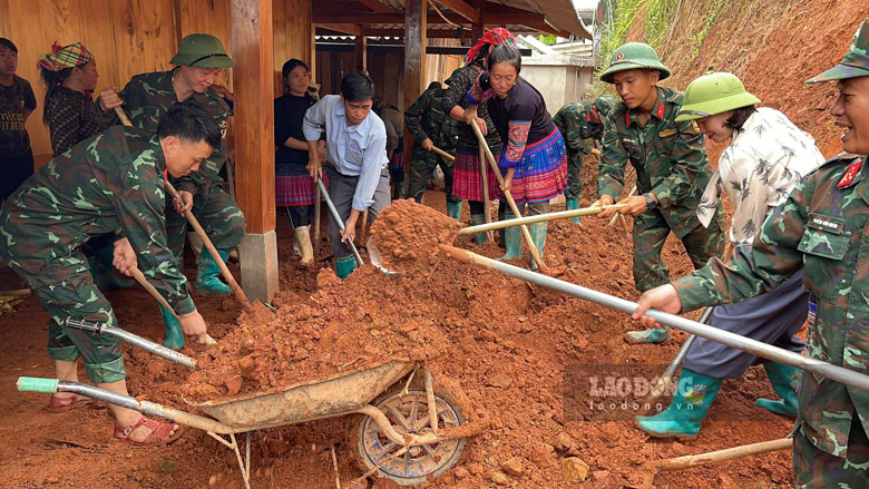 Officers and soldiers of Regiment 121 help people collect landslide soil and rocks. Photo: Ngoc Son
