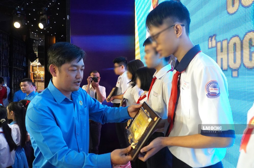 Phó Chủ tịch Ủy ban MTTQ Việt Nam TP, Chủ tịch LĐLĐ TP Đồng Nai Nguyễn Quốc Dũng trao biểu trưng cho các em học sinh được tuyên dương “Học giỏi - Sống tốt“. Ảnh: HAC