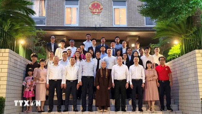 Vice Chairman of the Central Committee of the Vietnam Fatherland Front Hoang Cong Thuy takes a photo with representatives of representative agencies and the Vietnamese community in Japan. Photo: Bui Ha/VNA