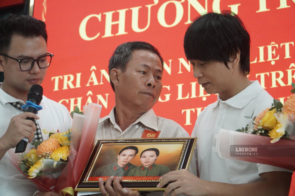 Các gia đình nghẹn ngào ôm di ảnh người thân hy sinh được nhận từ nhóm phục dựng Team Lee. Ảnh: Anh Tú