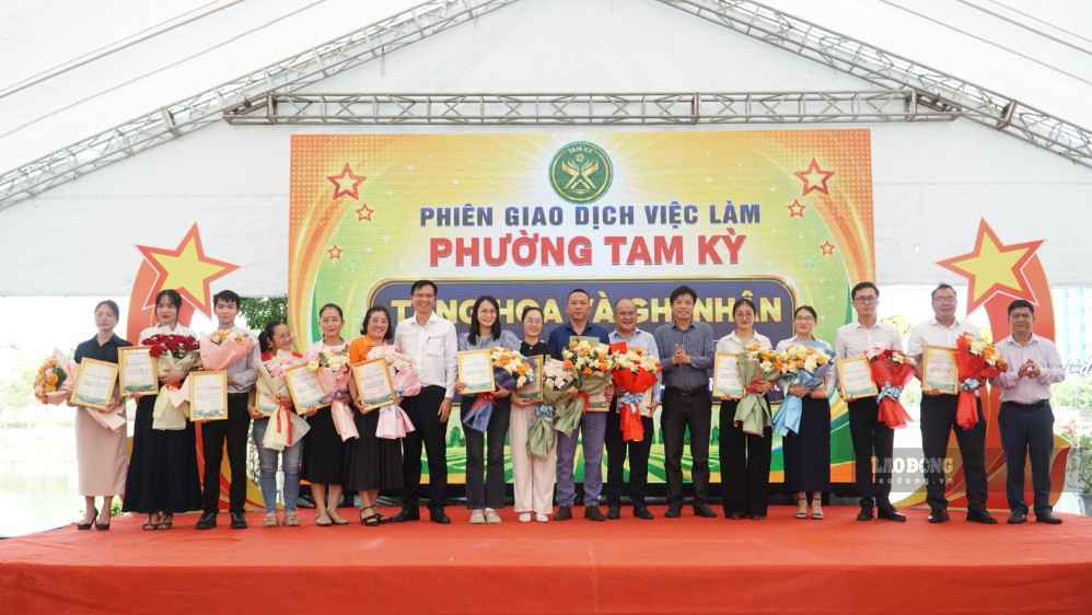 Lãnh đạo Sở Nội vụ Đà Nẵng và phường Tam Kỳ tặng hoa cho đại diện doanh nghiệp tham gia chợ việc làm. Ảnh: Hoàng Bin