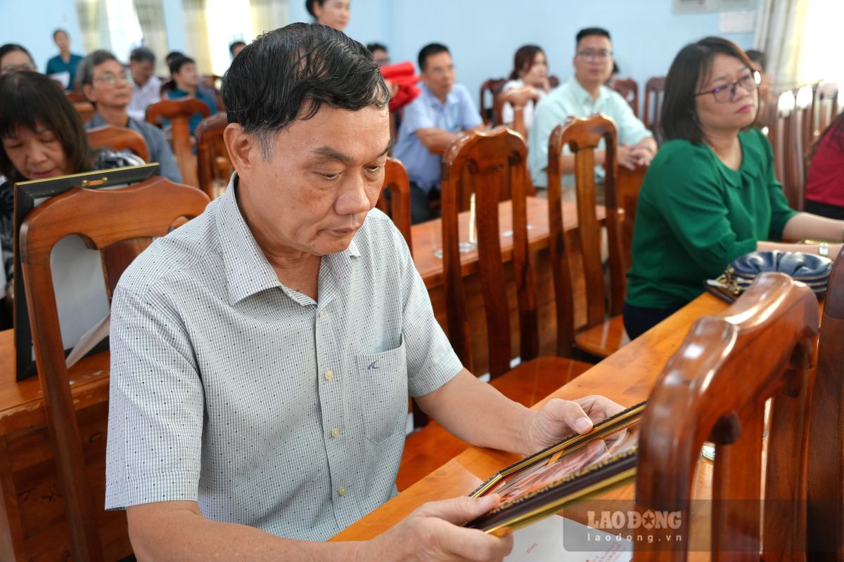 Mr. Nguyen Van Tuyen seemed to sink into memories after receiving his father's restored portrait. Photo: Thanh An