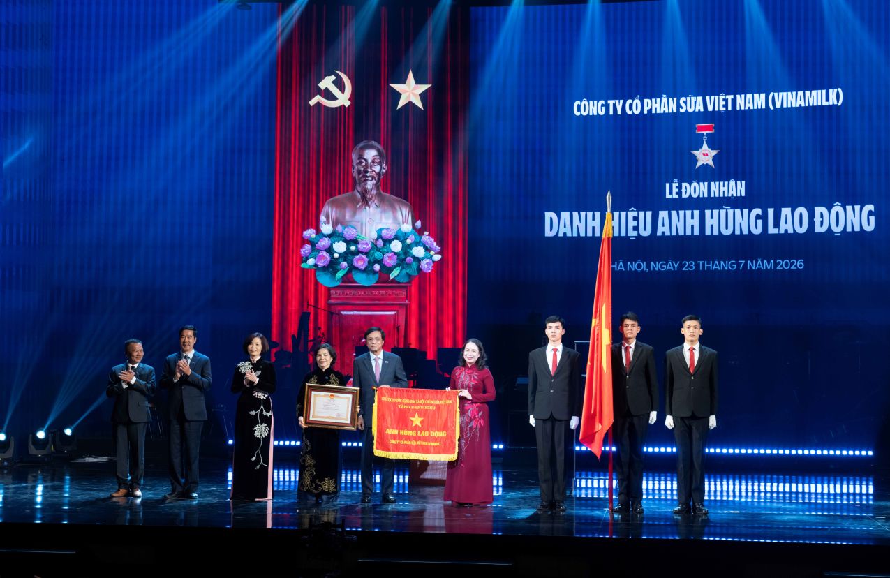 La secrétaire du Comité central du Parti, vice-présidente de la République socialiste du Vietnam, Võ Thị Ánh Xuân (en áo dài rouge), représentant le Parti et l'État, remet le titre de Héros du travail pour la deuxième fois au collectif Vinamilk. Photo: Minh Anh