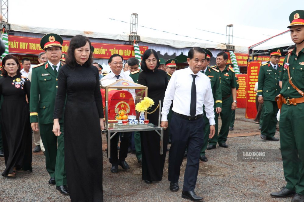 Các đại biểu di chuyển hài cốt liệt sĩ về nơi thờ cúng. Ảnh: HAC