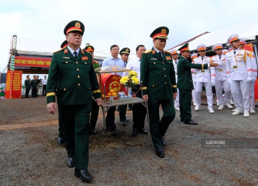 Các đại biểu di chuyển hài cốt liệt sĩ về nơi thờ cúng. Ảnh: HAC