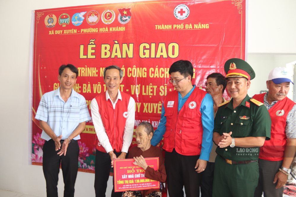 Gia đình bà Võ Thị Út (xã Duy Xuyên) xúc động tiếp nhận bảng hỗ trợ kinh phí xây dựng nhà từ Hội Chữ thập đỏ phường Hòa Khánh. Ảnh: Nguyễn Linh