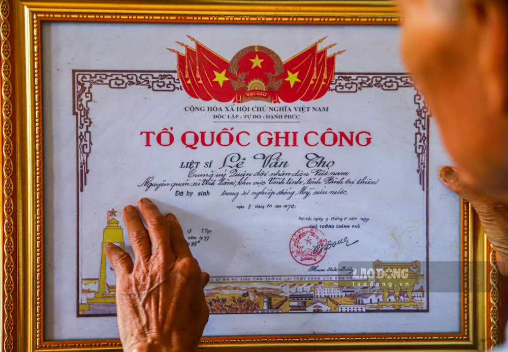 Người em trai nâng niu tấm Bằng “Tổ quốc ghi công” của người anh trai đánh giặc những chưa trở về. Ảnh: Nguyễn Luân