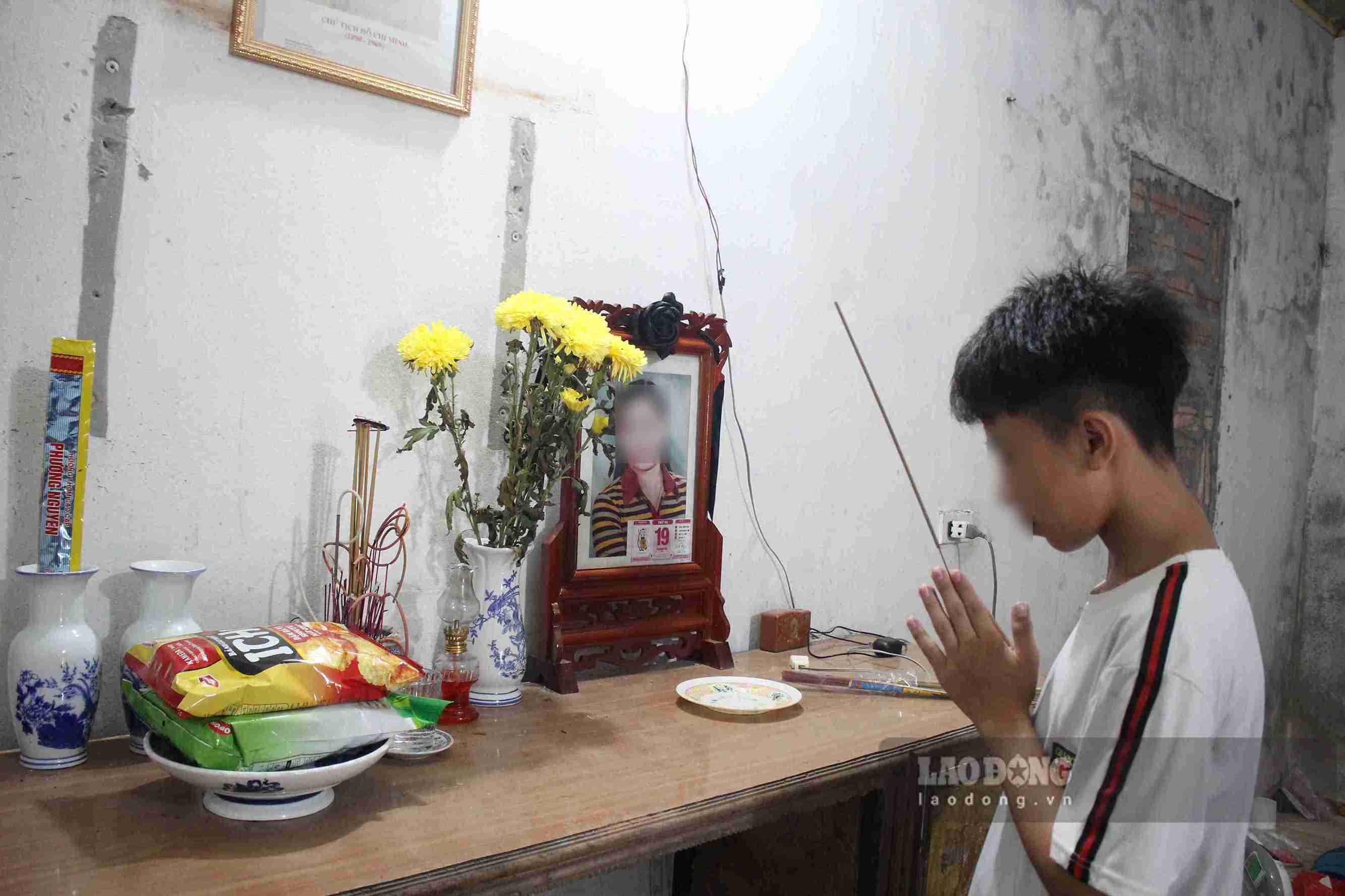 Dat lights incense on his mother's altar. His mother just passed away after more than a year of fighting rectal cancer. Photo: Mai Huong