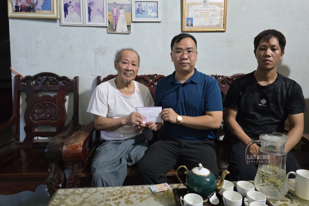Reporters hand over the support money from readers to Mr. Phan Van Thanh (left) and Mr. Phan Van Viet (right). Photo: Thu Thao