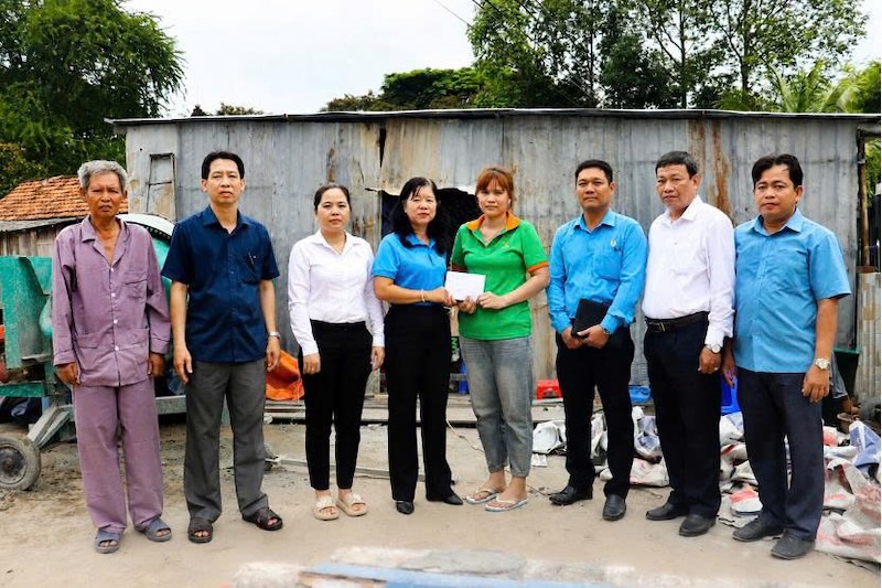 Chairman of Dong Thap Provincial Labor Federation Huynh Thi Tuyet Vui (fourth from the left) presents support to union member Nguyen Thi Thuy Trang. Photo: Luu Hung.