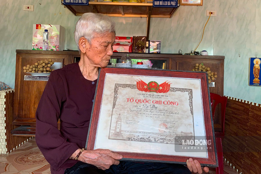 응우옌티토이 여사(95세)는 전장에서 영원히 잠든 남편 - 열사 레즈의 조국 공훈 훈장을 소중히 안고 있습니다. 사진: 즈엉안