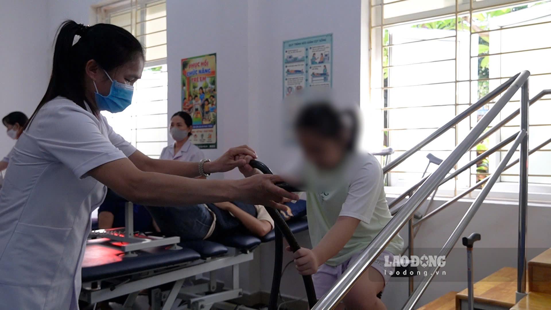 Bác sĩ hướng dẫn, phục hồi chức năng cho trẻ khuyết tật. Ảnh: Hạnh Thơm