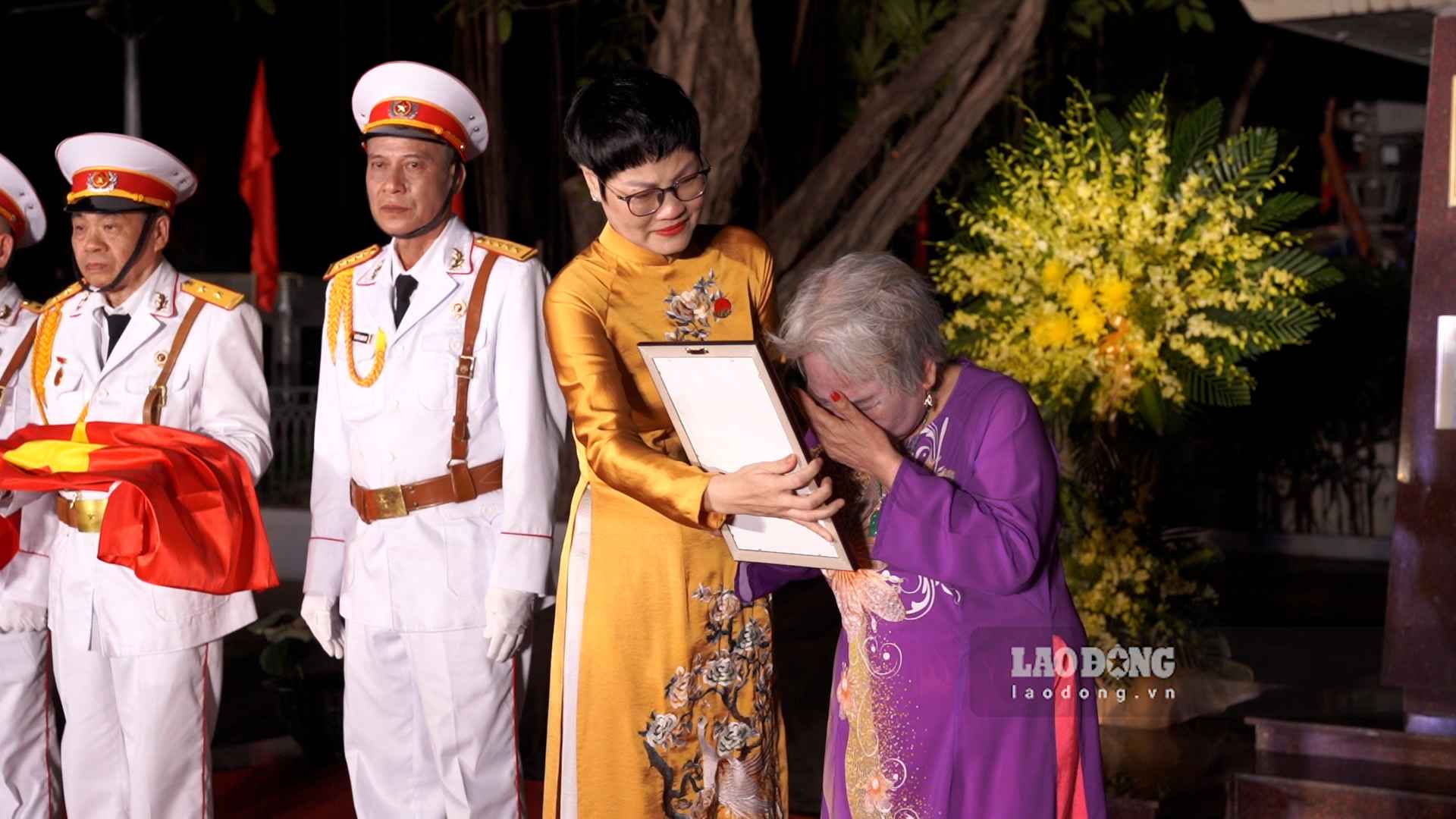 Thân nhân liệt sĩ bật khóc khi nhận lại ảnh chân dung phục dựng sau nhiều năm xa cách. Ảnh: Linh Anh