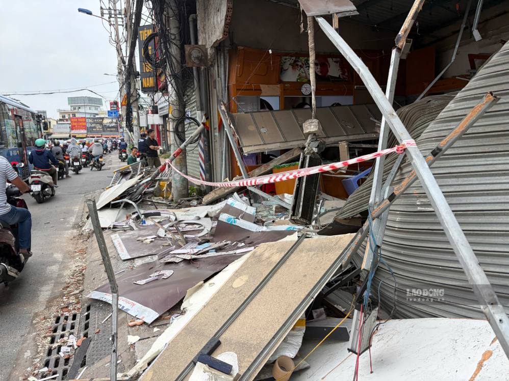 Un camion-benne percute le terre-plein central puis fonce sur un magasin de verre, endommageant de nombreux biens. Photo: Minh Tâm
